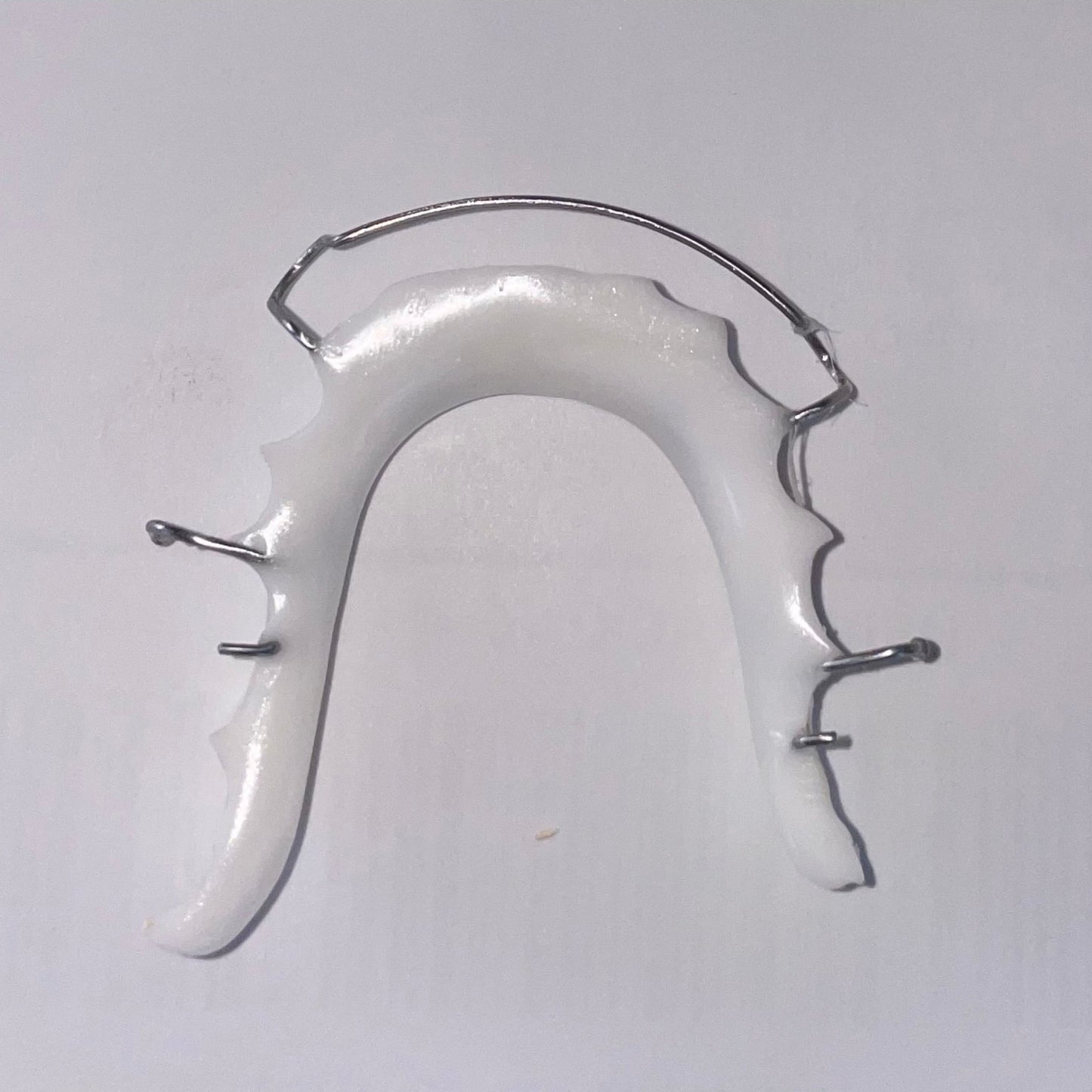 Lower Hawley retainer featuring sleek white acrylic and stainless steel wire