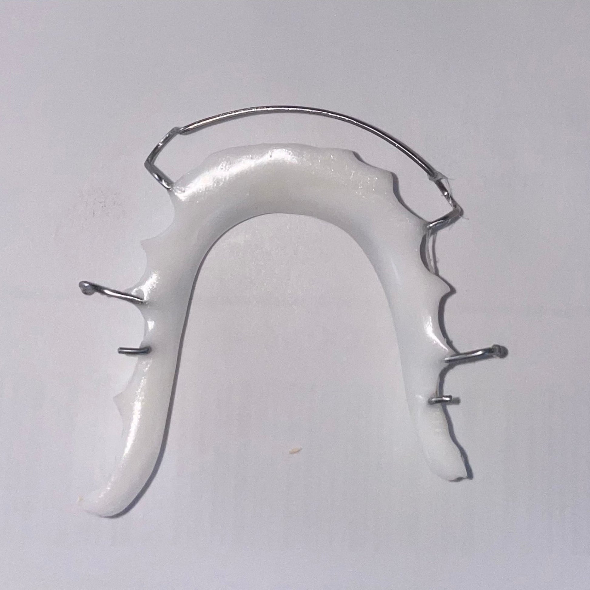 Lower Hawley retainer featuring sleek white acrylic and stainless steel wire